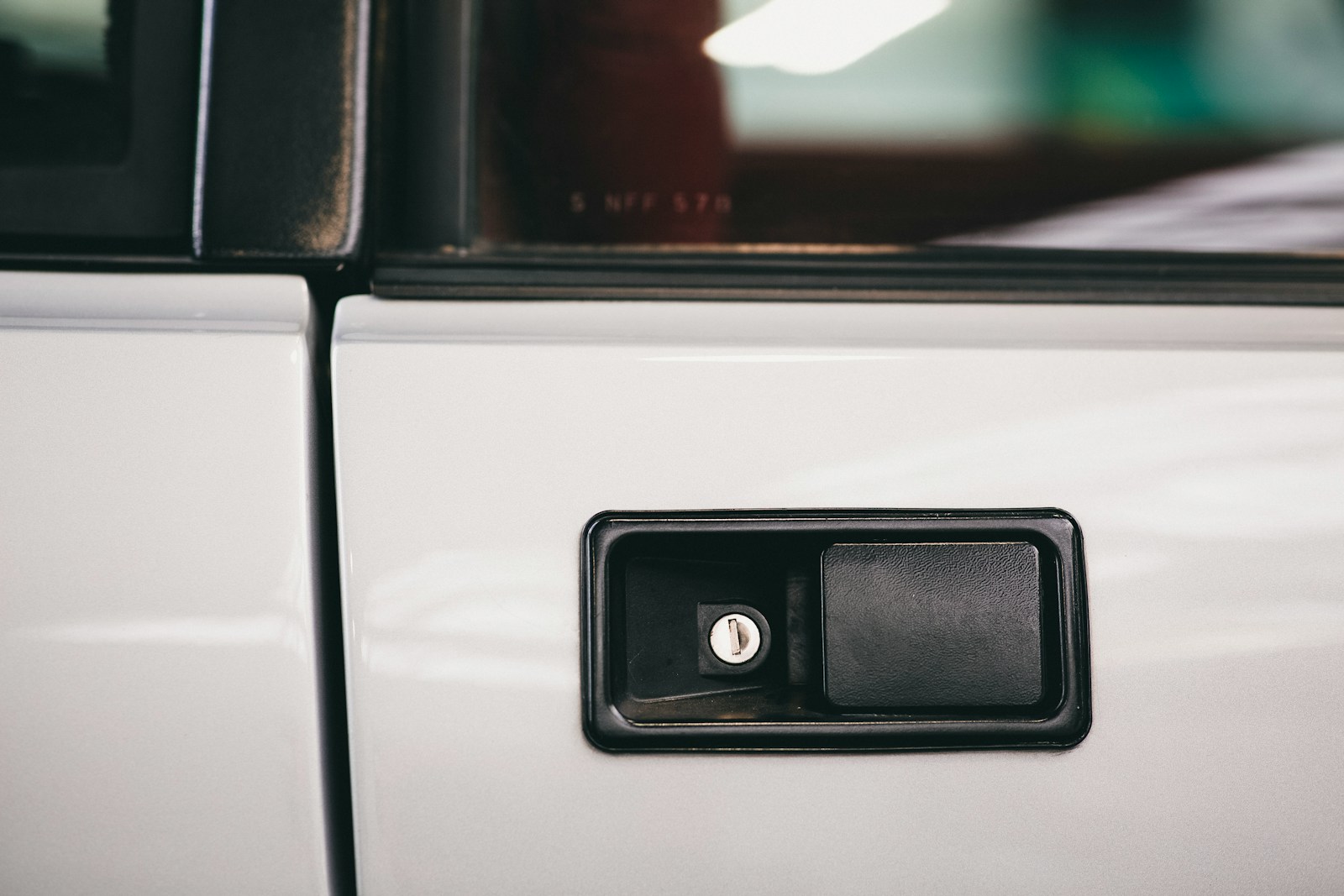 Close-up of a car door handle featuring a keyhole, highlighting the sleek design of automotive access points. Relevant for discussions on vehicle security.