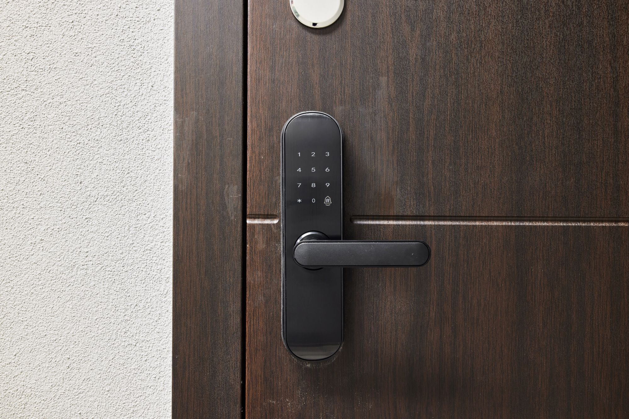 Smart lock keypad on a dark wooden door; a modern security feature for controlled access. Enhances safety and convenience for entry.