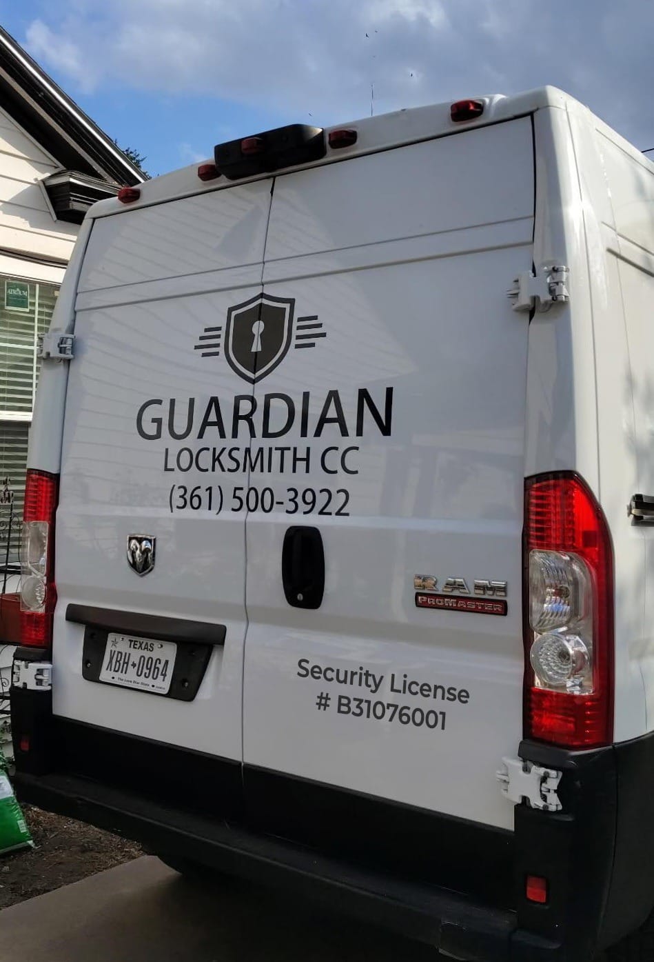 White van displaying "Guardian Locksmith CC" along with contact information, parked outside a home, emphasizing locksmith services and security.